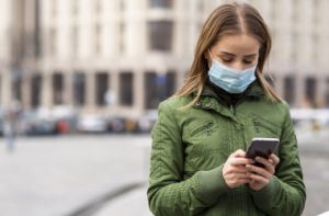 woman-outdoors-wearing-mask-using-mobile-phone-001_i