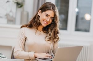 1-photo-of-lovely-white-woman-in-glasses-using-computer-with-charming-smile_197531-6702_i