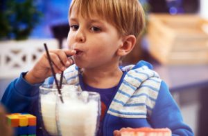 cute-cheerful-blond-boy-drinks-milk-cafe_i